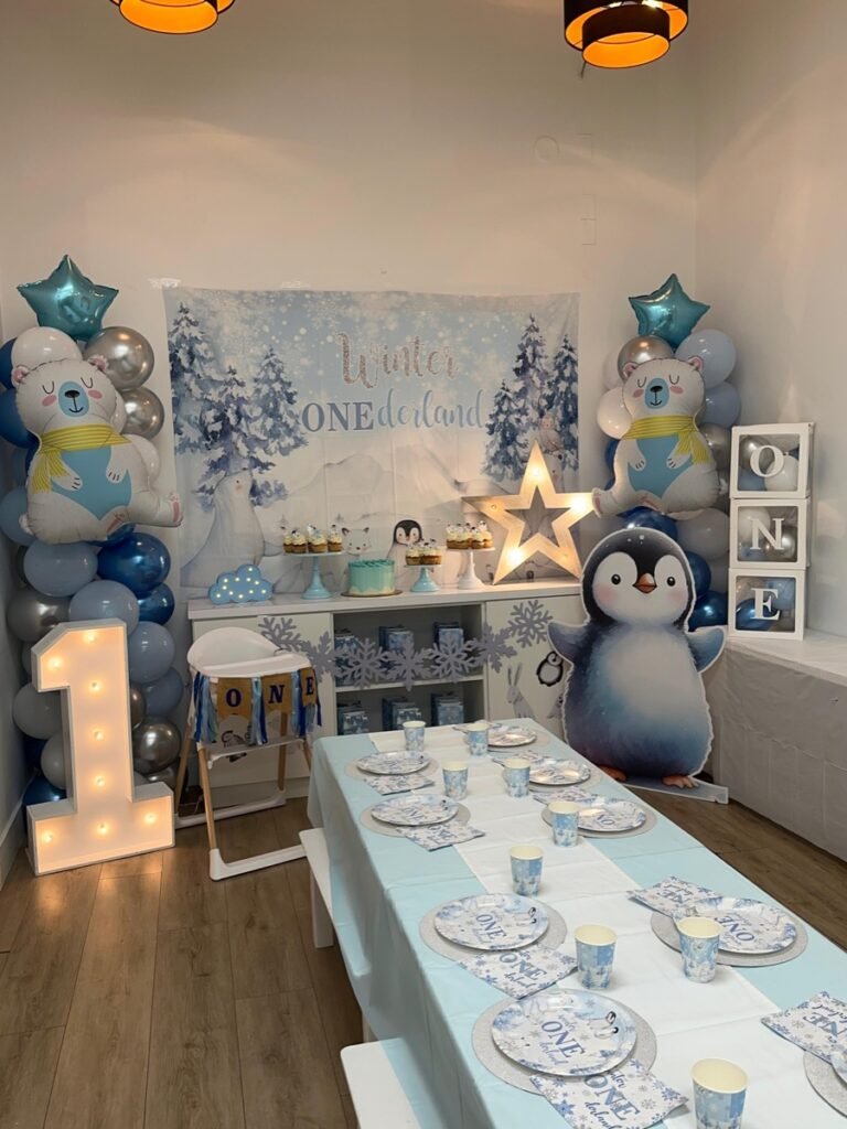 Arctic Winter ONEderland first birthday party with snowflake decorations, white and blue balloon arch at Kids Hideout Fort Lauderdale