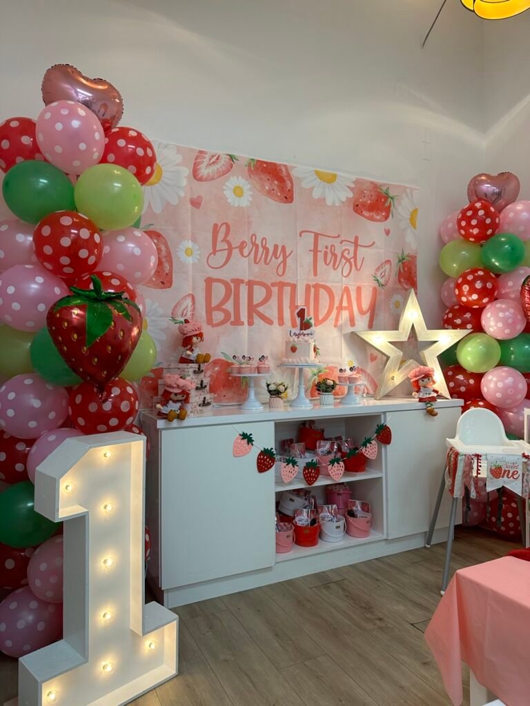 Berry First Birthday party decorations close-up with strawberry accents and gingham details at Kids Hideout