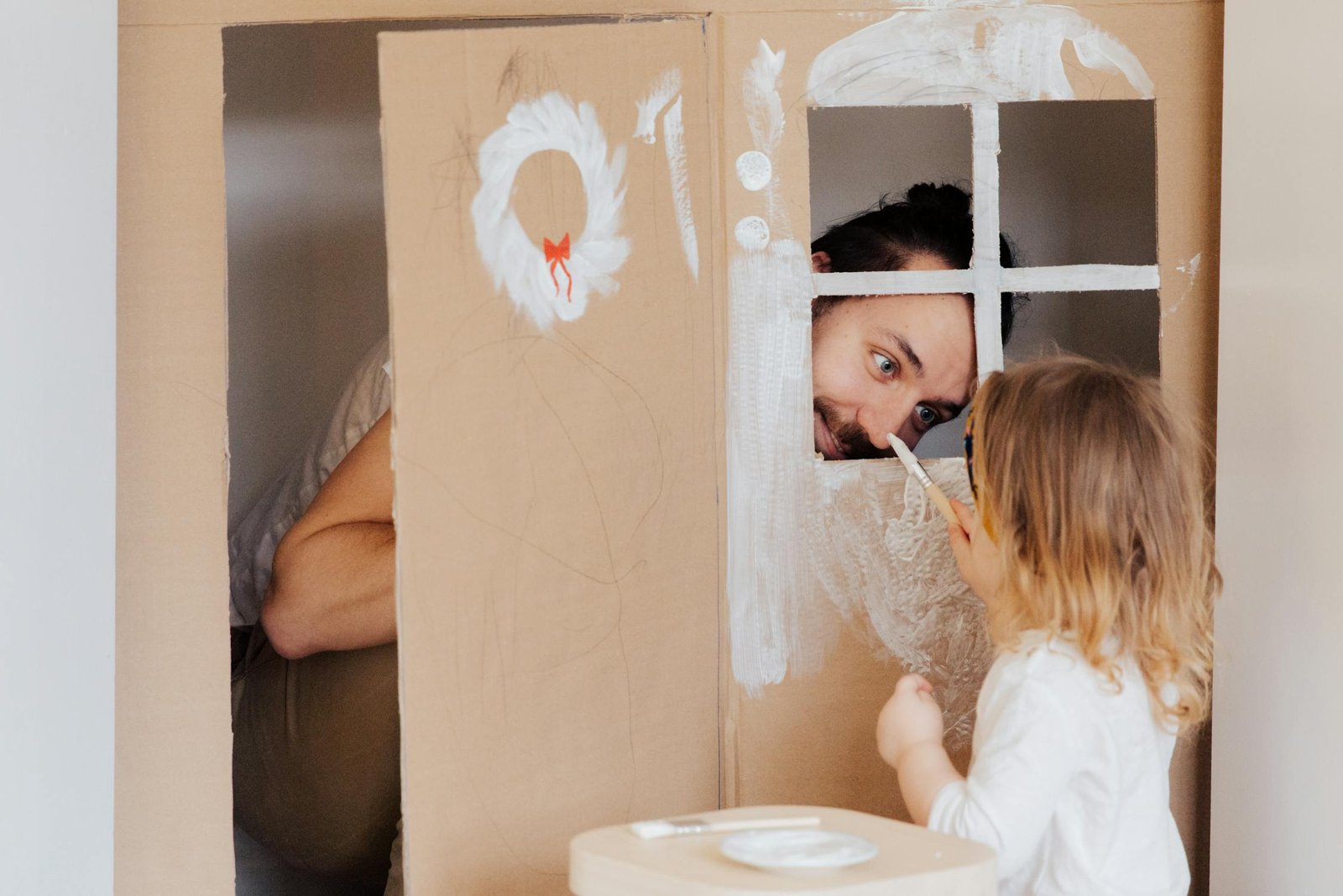 Dad and little girl painting and playing together during a parent-child activity