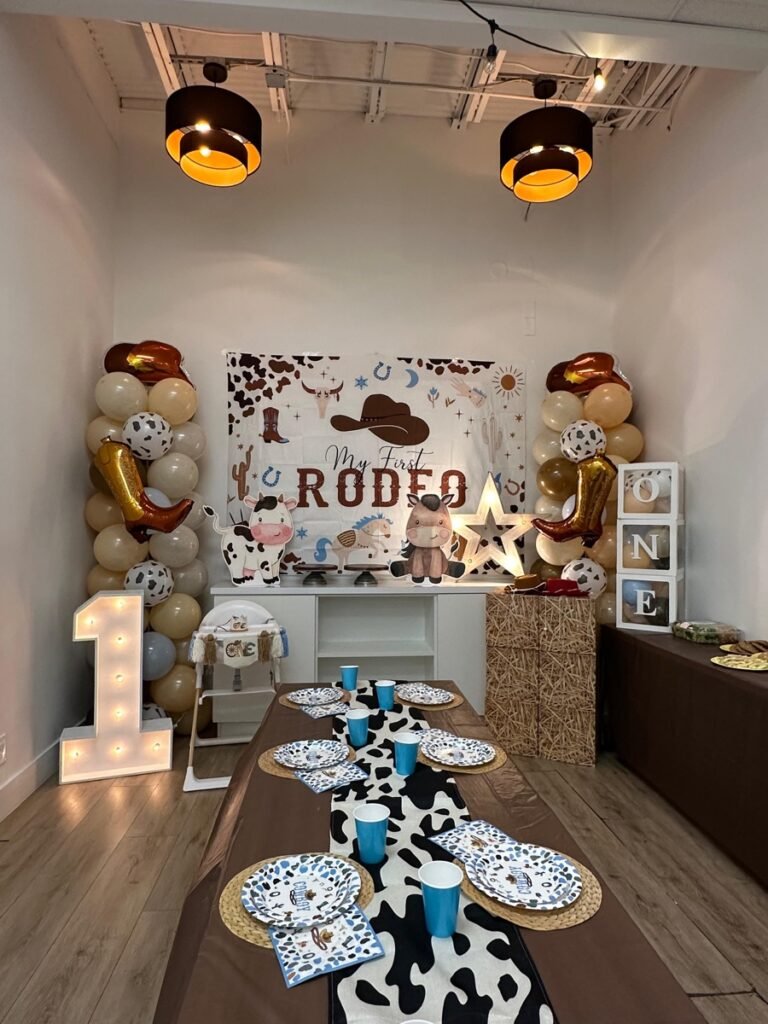 My First Rodeo boy first birthday party theme with cowboy decorations, hay bales, and western balloon garland at Kids Hideout Fort Lauderdale