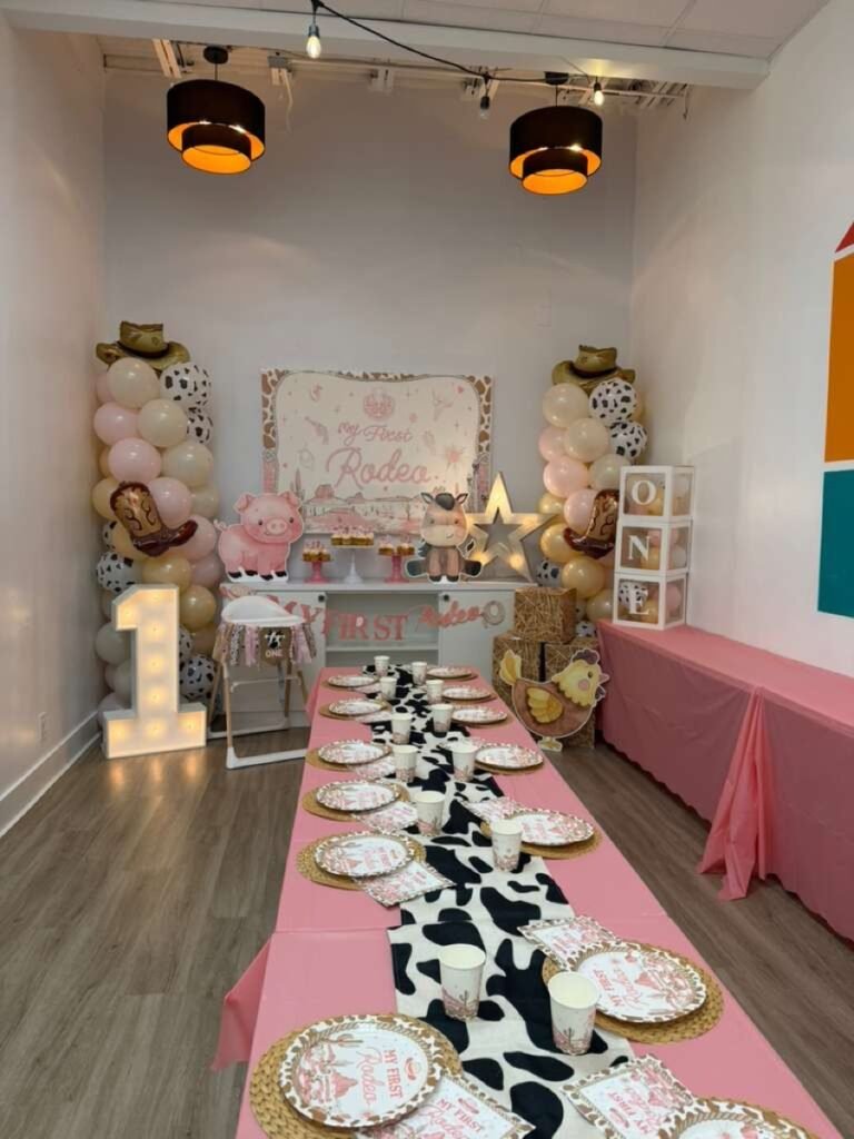 My First Rodeo girl first birthday party theme with pink cowgirl decorations and western balloon garland at Kids Hideout Fort Lauderdale