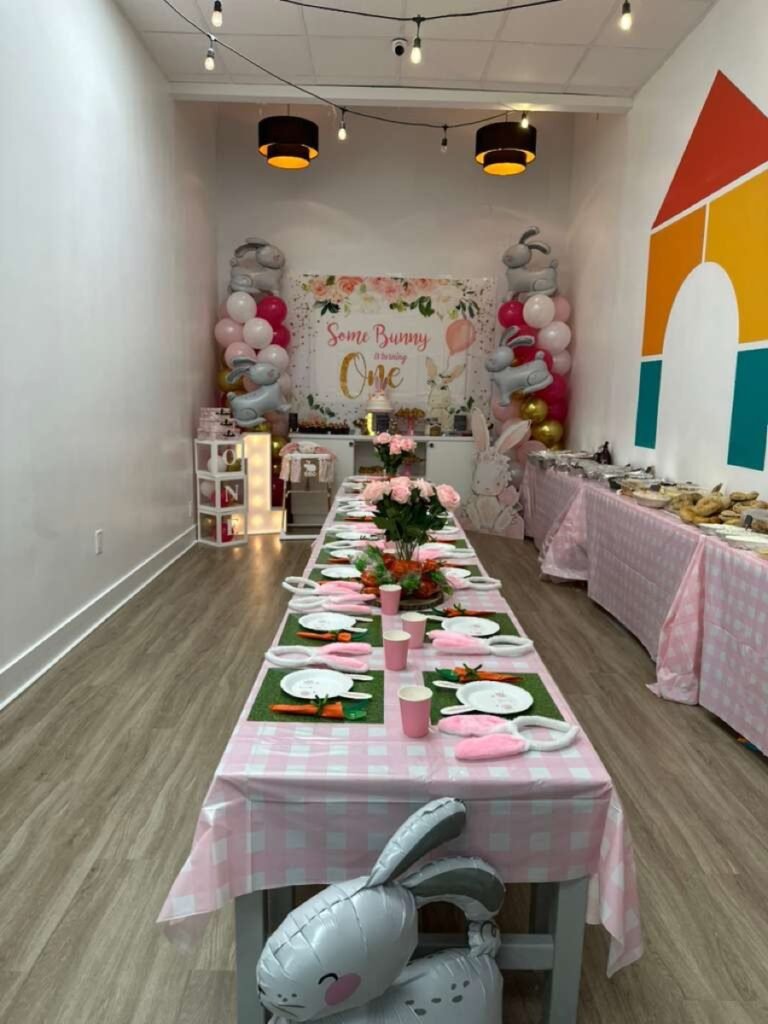 ONE Little Bunny birthday decorations with bunny figurines and pastel floral accents at Kids Hideout