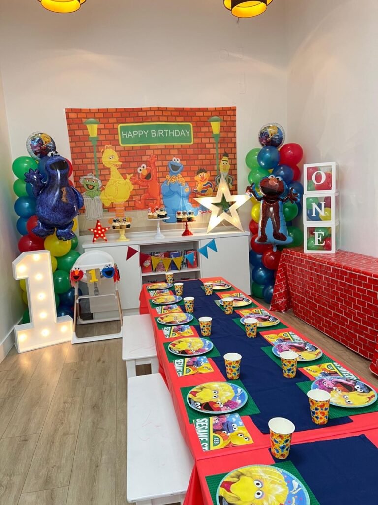 Sesame Street first birthday party theme with Elmo and Cookie Monster decorations and colorful balloon garland at Kids Hideout Fort Lauderdale
