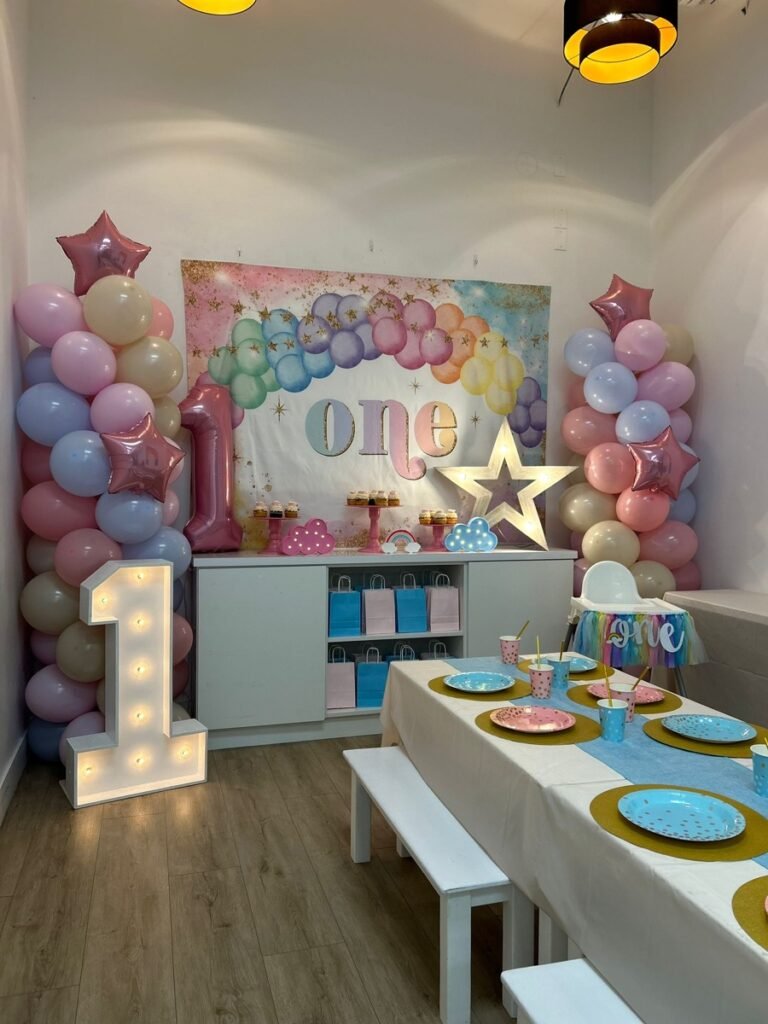 Una de ONE fiesta birthday decorations with colorful balloon garland and papel picado at Kids Hideout