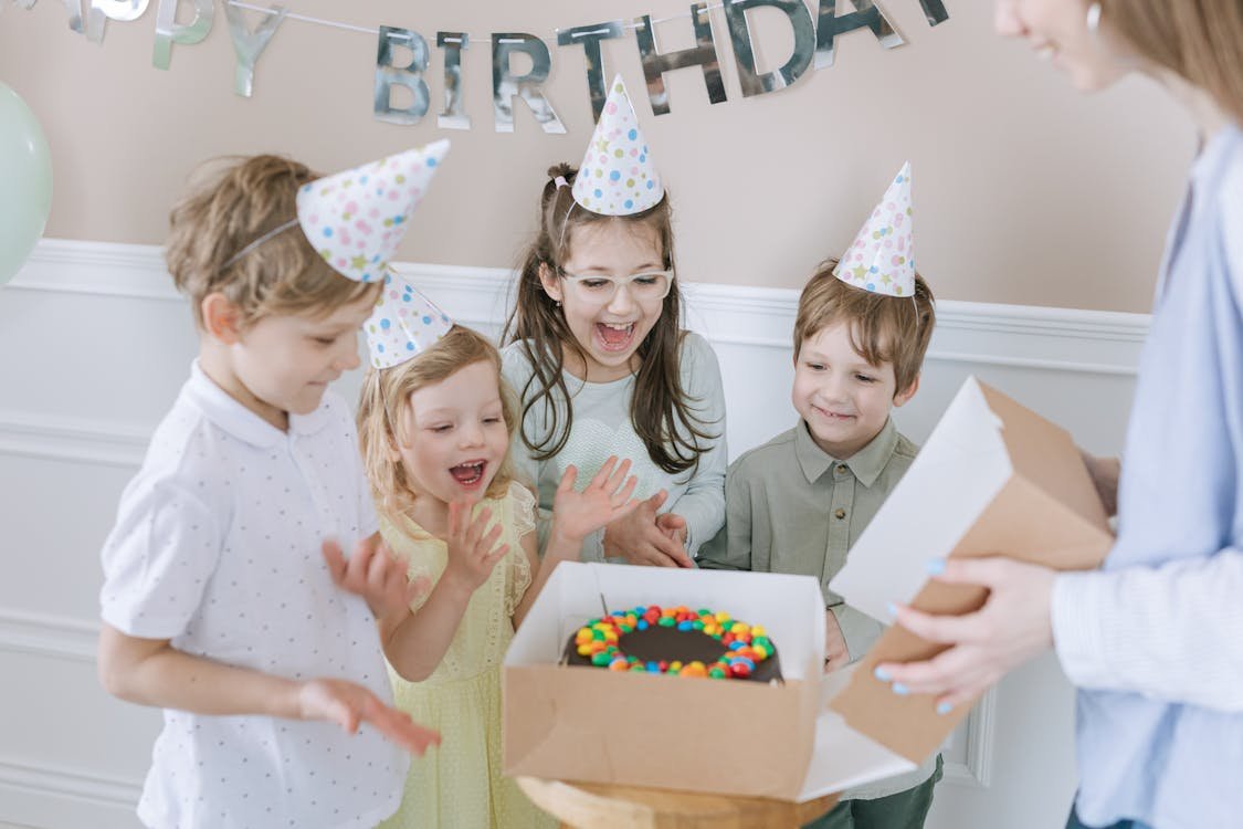 Kids celebrating at a birthday party with cake