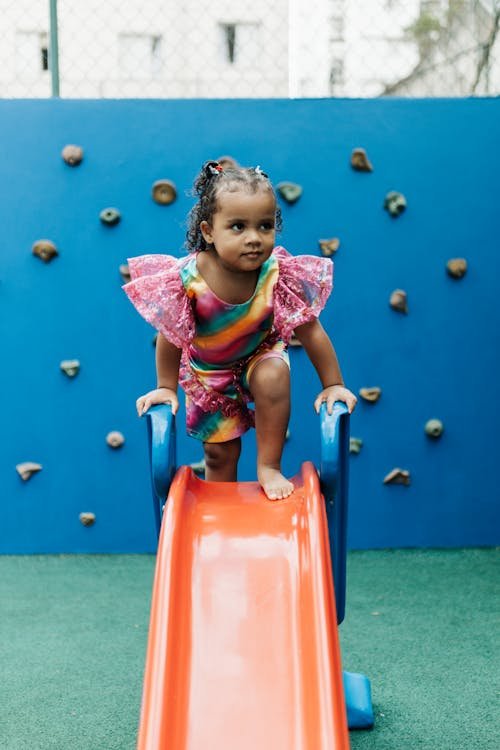Little girl enjoying an indoor slide at a kids play area in Fort Lauderdale